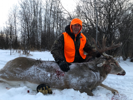 hunter holds hunted trophy whitetail deer